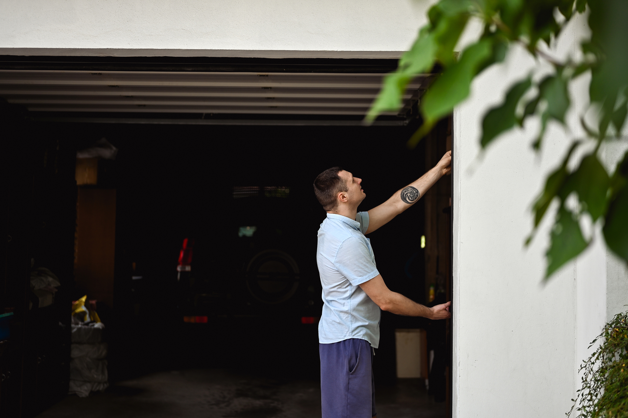 Millennial man working with a gate in a garage