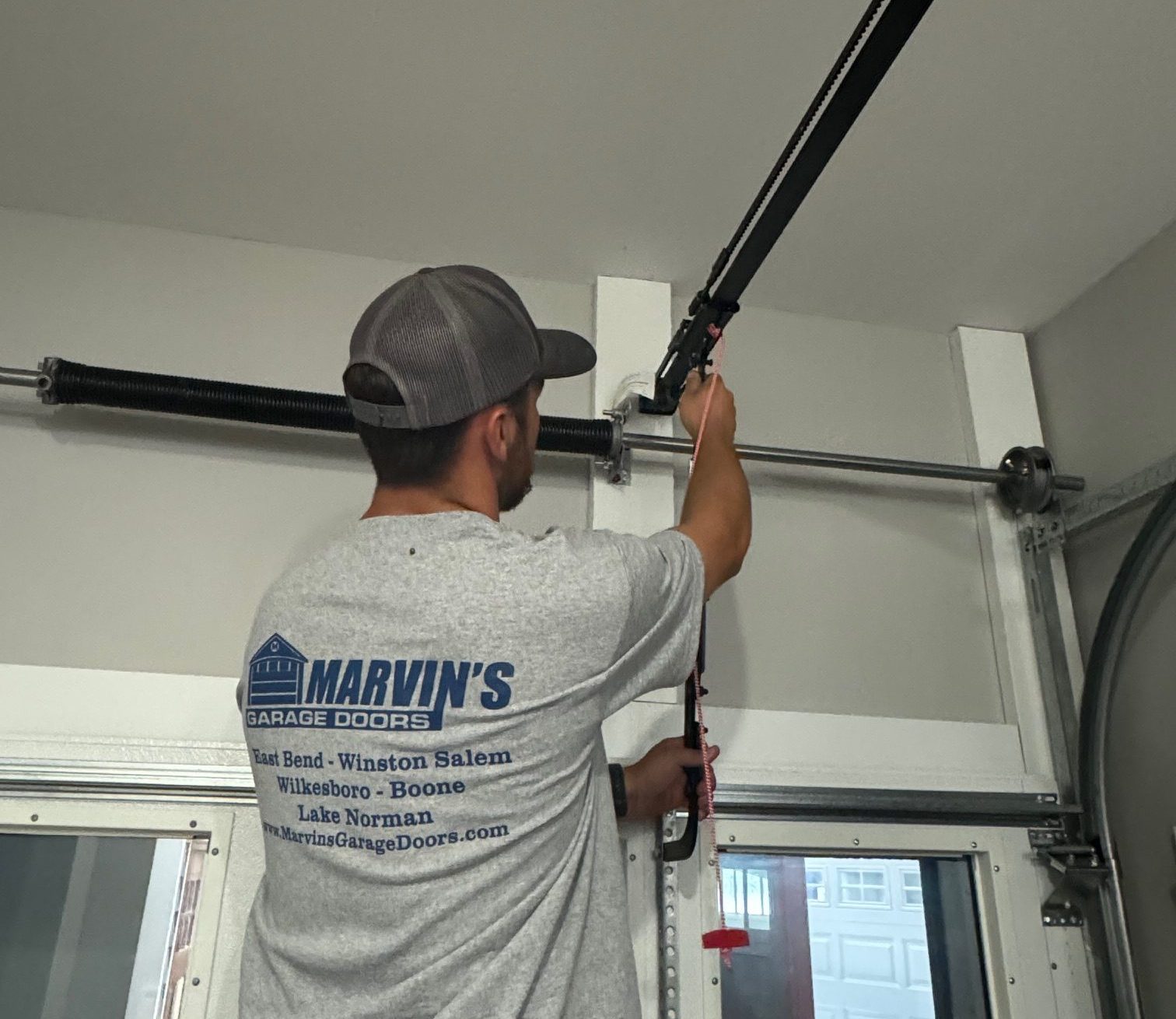 Marvin's Employee fixing garage door